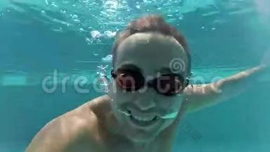 快乐英俊的年轻人在游泳池，水下观景。 假期暑期时间.. 操作摄像机